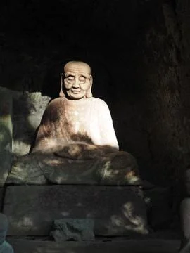 Ancient Buddhist arhat stone statue found in a small cave alcove on Mt. Nokogiri Stock Photos