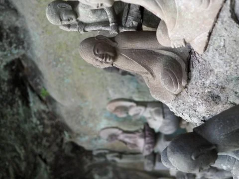 Ancient Buddhist arhat stone statue found in a small cave alcove on Mt. Nokogiri 写真素材