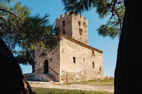 Ancient Byzantine tower framed by pine tree branches in Nea Fokea in Greece Stock Photos