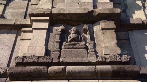 Ancient carved deity sits within a weathered stone niche on the sacred faca.. Stock Footage 341544094