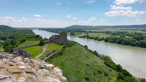 Ancient castle ruins overlooking a river and lush green hills, with tourists Vidéo 299937386