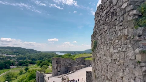 Ancient castle ruins overlooking a river and lush green hills Stock Footage 301649348