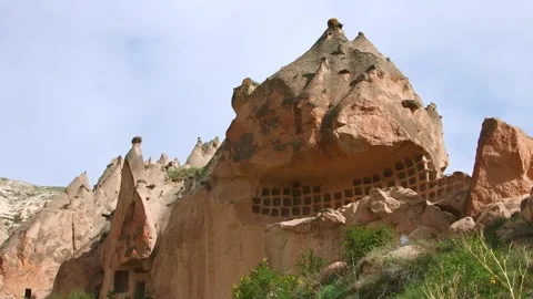 Ancient cave dwellings carved into the unique volcanic rock formations of Zelve Stock Footage 332544597
