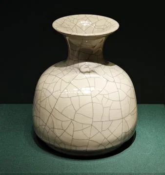 An ancient ceramic vase with cracks on the surface exhibited Stock Photos