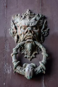 Ancient clapper on an ancient door Stock Photos