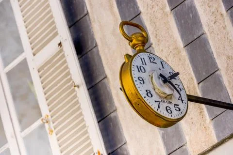 Ancient clock above the window of a watchmaker Stock Photos
