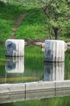 Ancient columns with reflection on water at archeological site area. Vertical Foto stock