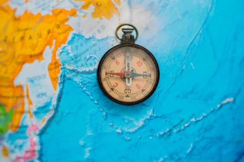 Ancient compass on the background of the globe. Stock Photos