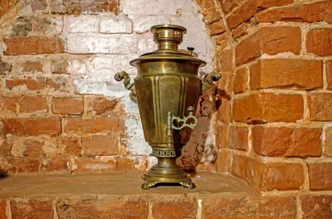 Ancient copper samovar stands in the form of scenery on the background of the Stock Photos