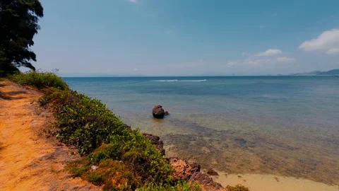 Ancient Coral Reef Coast with Clear Shallow Water and Solitary Rock Stock Footage 337582899