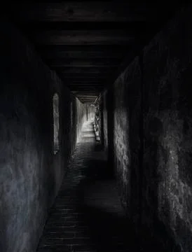 Ancient corridor with beams of light. Dark hallway in a medieval building. Stock Photos