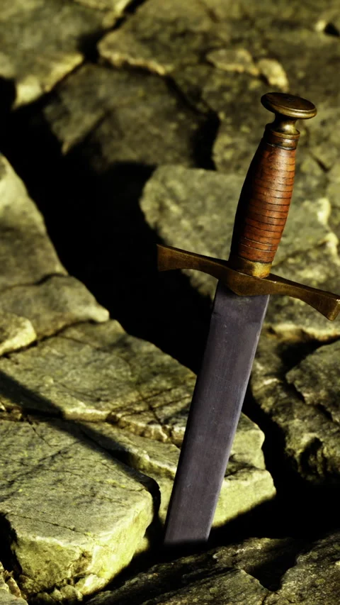 Ancient dagger embedded in rough cobblestone surface in shadow Stock Footage 326162586