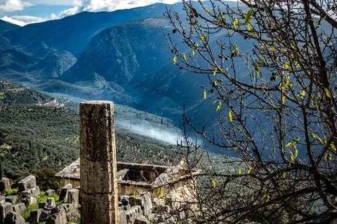 Ancient Delphi. Delfos column on slope with smoke and valley. Greece Foto stock