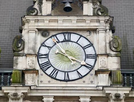 Ancient dial with moss. Old clock featuring Roman numerals and moss accents.. Foto stock