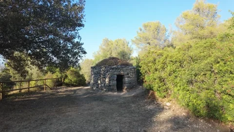 Ancient dry stone cabin in Mediterranean countryside Stock Footage 344803386