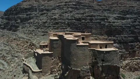 Ancient Earthen Fortress Perched on Rocky Cliff Face Stock Footage 335636554