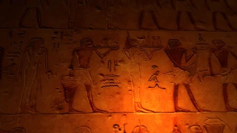 Ancient Egyptian artwork inside tomb of the pyramids lit by candle ALT Stock Footage 100998398