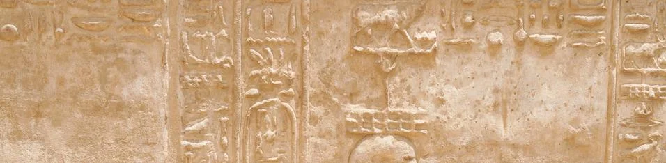 Ancient Egyptian hieroglyphs on the stone wall close-up banner Stock Photos