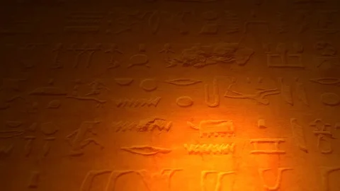 Ancient Egyptian lettering or language inside tomb of the pyramids lit by candle Stock Footage 100998427