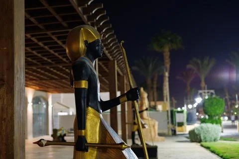 Ancient Egyptian pharaoh statue under night sky with palm trees on September 3, Stock Photos