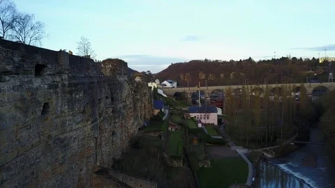 Ancient fort built in to a wall with a valley village, drone flyby Stock Footage 74643498