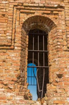 Ancient grated window in old brick building Stock Photos