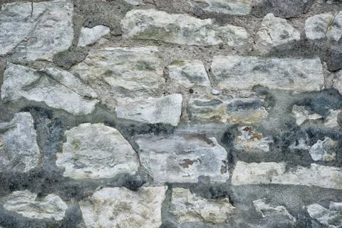 Ancient grey stone wall flat background closeup Stock Photos