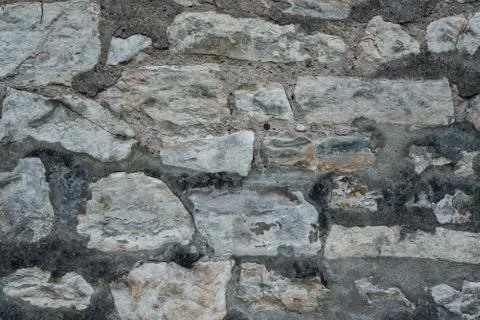 Ancient grey stone wall flat background closeup Stock Photos