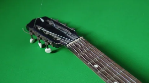 An ancient guitar with broken string on a green floor Stockbeeldmateriaal 118259363