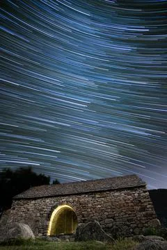 Ancient hermitage under star trails sky at night Stock Photos