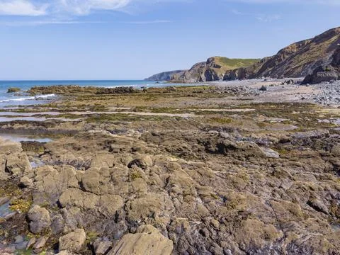 Ancient historic rock formations at the base of the Cornish cliffs Fotos de archivo