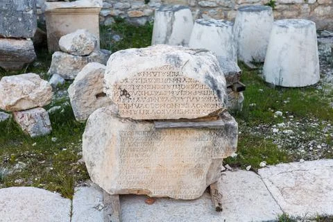 Ancient inscribed stone blocks resting on wooden supports Fotos Stock