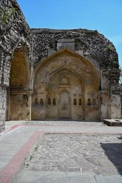 Ancient Islamic arch facade inside ruined medieval fort with intricate heri.. Фото