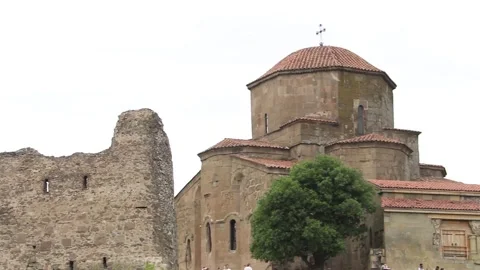 Ancient Jvari Monastery and stone fortress ruins on green hill Видео 340969747