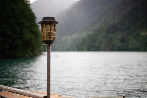 Ancient lantern on the background of the Ritsa lake. Abkhazia Stock Photos