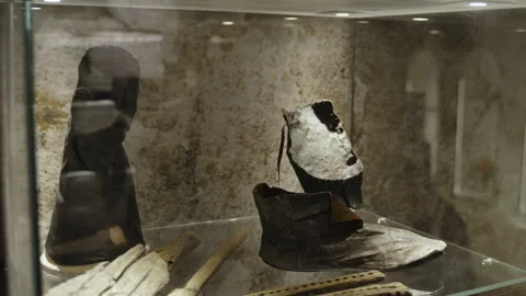 Ancient leather elements of people clothing stand behind glass in museum. Stock Footage 238847097