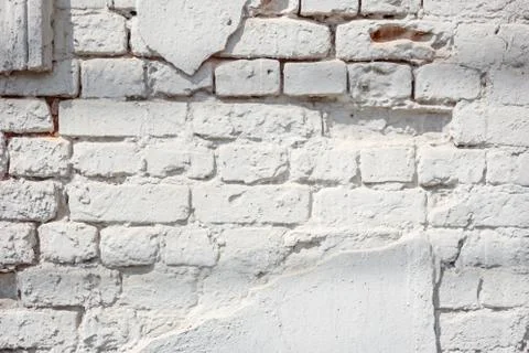 Ancient light blue brick wall with peeling plaster. Texture or background. Stock Photos