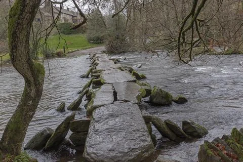 Ancient man made clapper bridge across a fast flowing ford Stock Photos
