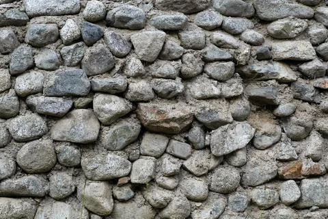 Ancient masonry wall built with natural gray river stones 库存照片