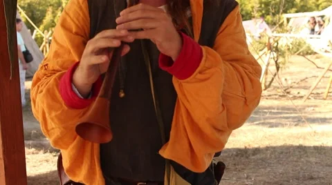 Ancient Medieval Man is Playing on the Old Flute During Historical Reenactment Stock Footage 56279635