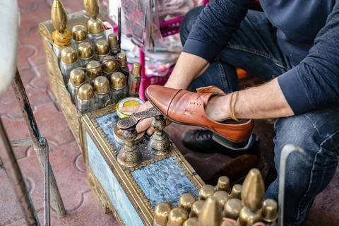 Ancient method of shoe cleaning. Man cleans shoes with help of shoe polish Stock Photos