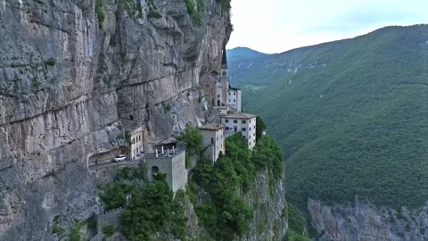 Ancient monastery built into a steep limestone cliff face . Video stock 342902021
