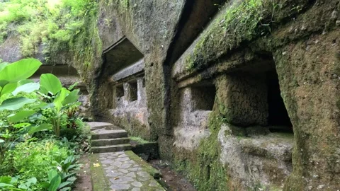 Ancient moss-covered rock temple path with carved windows and doors Stock Footage 339952864