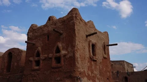 Ancient mud brick building with arched windows under blue sky 動画素材 347972709