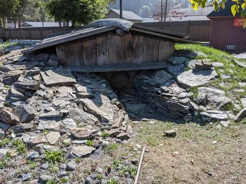 An ancient Native American house with a tiny round door and unique rock piles Stock Photos