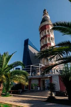An ancient openwork tower against the background of modern skyscrapers. Stock Photos