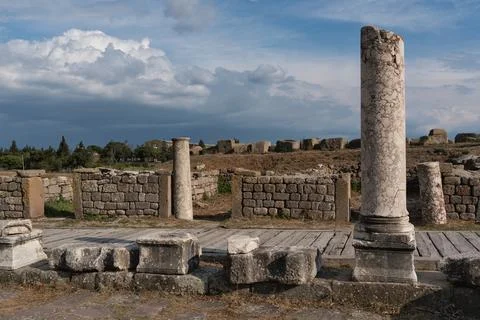 Ancient Pergamon ruins with weathered columns and stone walls against a cloudy Stock Photos
