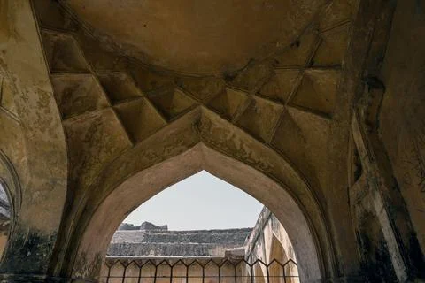 Ancient pointed stone arch with weathered vaulted ceiling inside historic f.. Fotos Stock
