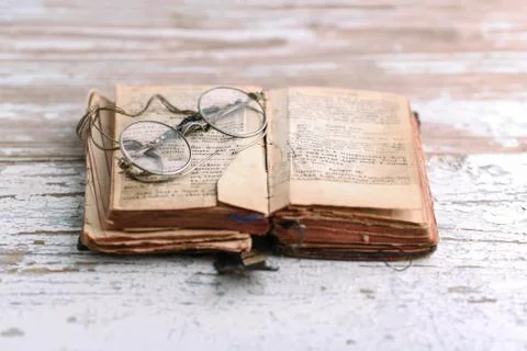 Ancient prayer book with old spectacles, Old Slavic language in the book Fotos Stock