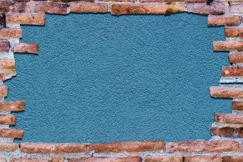 Ancient red brick wall over background blue. Stock Photos